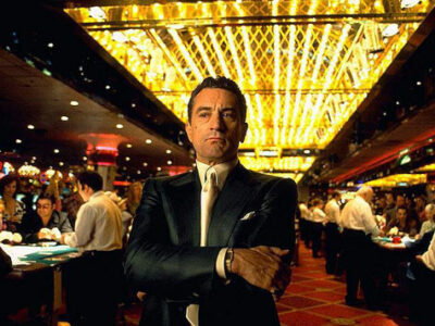 Robert De Niro stands with arms folded inside a glitzy Las Vegas casino in Martin Scorsese's film Casino.