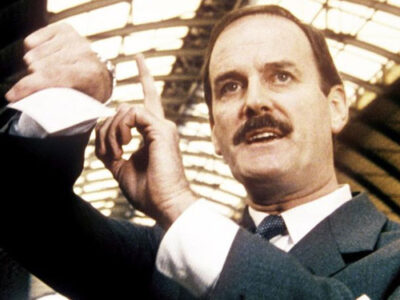 John Cleese tapping his watch in comedy film Clockwise (1986)