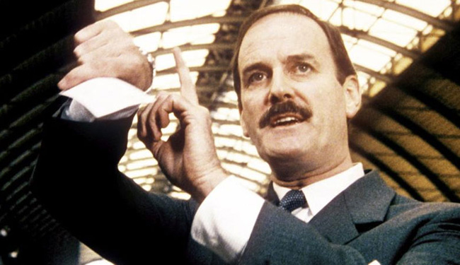 John Cleese tapping his watch in comedy film Clockwise (1986)