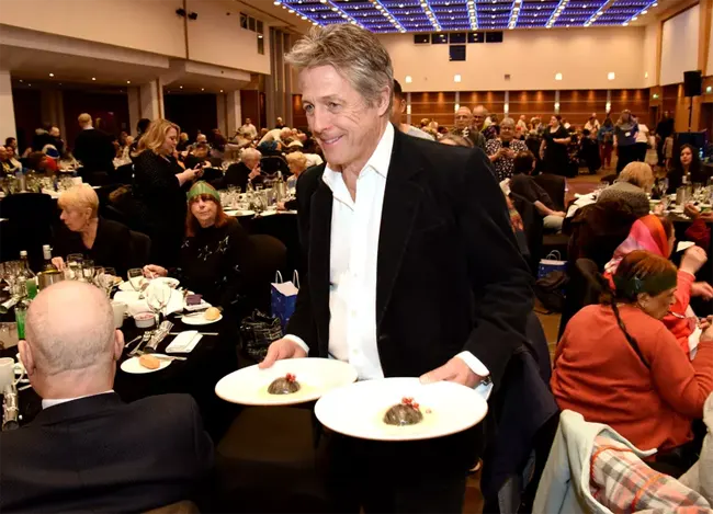 Hugh Grant handing out Christmas dinner in London