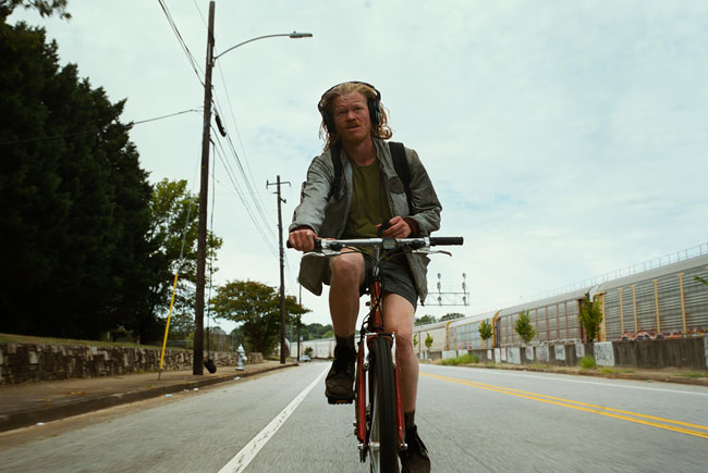 Jesse Plemons on a bicycle in the film Bugonia.