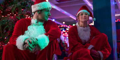 Jingle Bell Heist actors Olivia Holt and Connor Swindells in Santa Claus costumes.