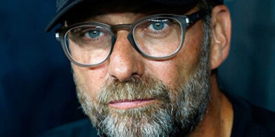 Former Liverpool manager Jurgen Klopp wearing a baseball cap and glasses while managing English Premier League team Liverpool.