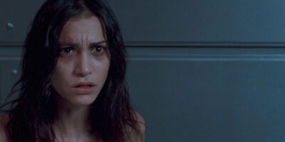 A young woman with brunette hair looks distressed in the 2008 film Martyrs.