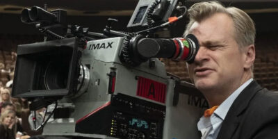 Christopher Nolan looks through an IMAX camera viewfinder.