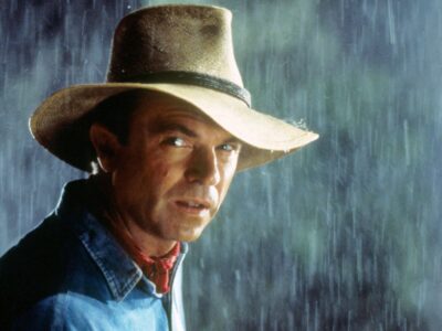 Sam Neill standing in the rain protected by a fedora hat in Steven Spielberg's film Jurassic Park (1993)