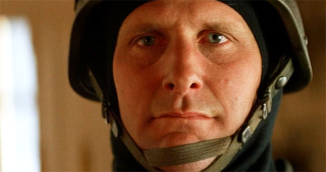 Jeff Daniels, in close-up, staring at the camera wearing a police SWAT helmet in the film Speed.