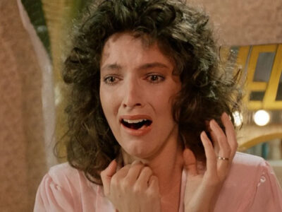 Madolyn Smith shrieks in fright as she sees something off-camera that shocks her in the 1987 film, The Caller.